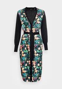 Lang vest met een zwart gebreid lichaam en een levendige bloemenprint in roze, geel en blauw. Gemaakt met een strik in de taille met een bijpassende riem.