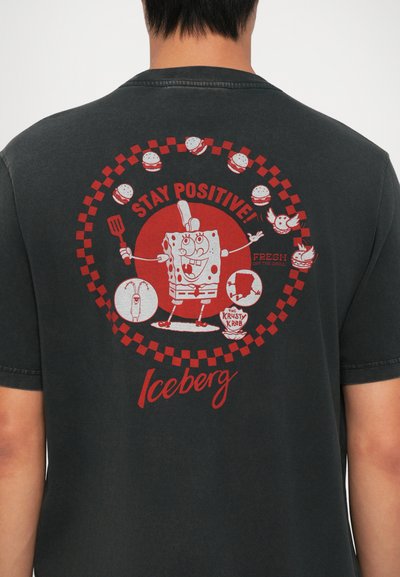 Juodasis medvilnės marškinėlis su grafiniu piešiniu, kuriame vaizduojamas SpongeBob Kvadratkojis, raudonu tekstu ir maisto ikonėlėmis, sudarančiomis apvalią šachmatų lentą.