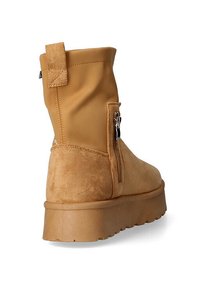 Stivaletto beige che presenta una combinazione di materiali lisci e testurizzati, una cerniera laterale e una suola chunky e sollevata.