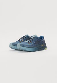 Zapatillas deportivas azules con parte superior de malla, patrón texturizado y acentos naranjas. Suela gruesa con goma Goodyear para mayor tracción.