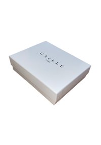 Scatola rettangolare bianca con finitura lucida, etichettata "GAëLLE PARIS" in lettere maiuscole nere sul coperchio. Design semplice ed elegante.