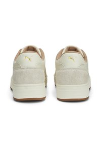 Beiga lädersneakers med mockadetaljer, guldiga logotyp, vadderad tunga och gummisulor, med en lågskuren design och rund häl.