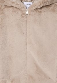 Giacca zip-up in finta pelliccia beige con cappuccio; texture morbida, accessori in argento e cuciture a contrasto. Etichetta con la scritta "Terranova."