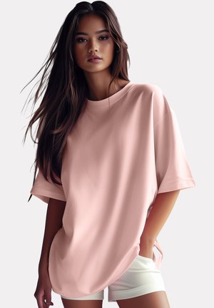 T-shirt rose surdimensionné en tissu léger avec des manches courtes, un col rond et des coutures d'épaules tombantes, associé à un short blanc.