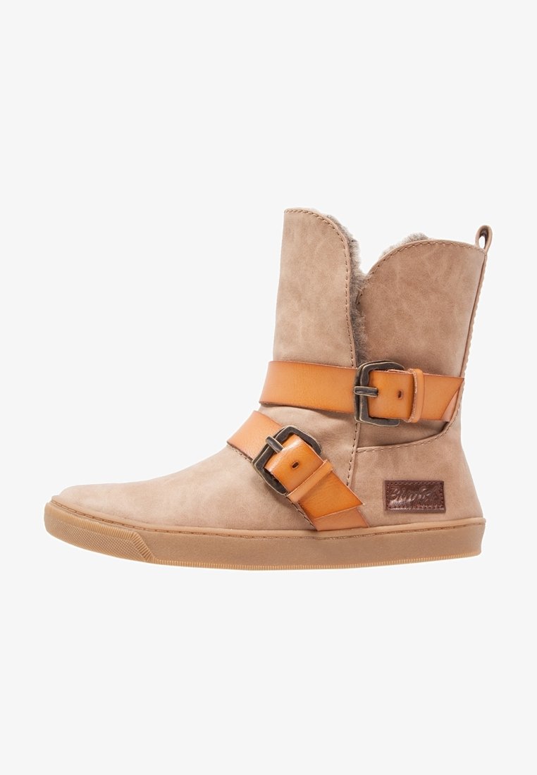 Botte mi-mollet beige avec des sangles en cuir marron clair et des boucles, doublure douce visible en haut, et une semelle en caoutchouc plate.