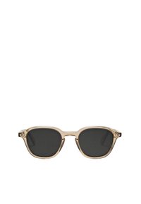 Transparent beige solglasögon med svarta linser, rektangulär form, metallaccenheter längs benen och distinkta rundade hörn.