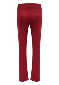 Röda sportbyxor med en mjuk textur, åtsittande design och elastisk midja; inga synliga fickor eller ytterligare detaljer.