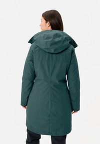 Parka verde isolata con cappuccio, caratterizzata da una texture liscia e una lunghezza fino alla metà coscia. Sono visibili anche dettagli delle cuciture e un retro dritto.