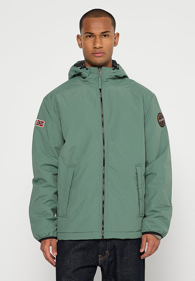 Veste isolée verte avec zip à l'avant, capuche, deux poches latérales et une patch logo sur la manche gauche. Texture lisse, design de longueur intermédiaire.