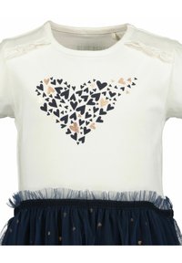 Haut blanc à manches courtes avec un motif de cœurs bleu marine, présentant des accents dorés et une jupe en tulle bleu superposée avec des détails en points dorés.