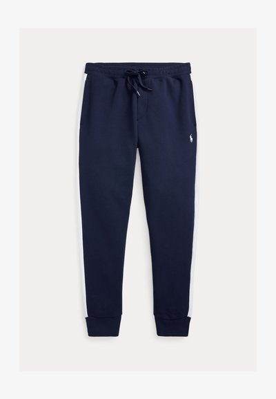 Mörkblå mjukisbyxor med vita sidor, elastisk midja med dragsko, ribbade muddar och en liten broderad logotyp på övre benet.