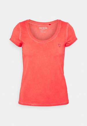 Koraalroze katoenen t-shirt met korte mouwen, ronde halslijn en klein driehoekig logo op de linker borst. Zachte textuur, casual pasvorm.