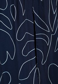 Navy fabric with white, organic leaf patterns; features a split detail, smooth texture, and lightweight material suitable for casual wear.