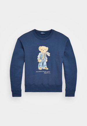 Sudadera azul marino con un oso de peluche impreso en la parte delantera, vistiendo chaqueta vaquera, jeans y bufanda, con el texto "Polo Bear by Ralph Lauren" debajo.