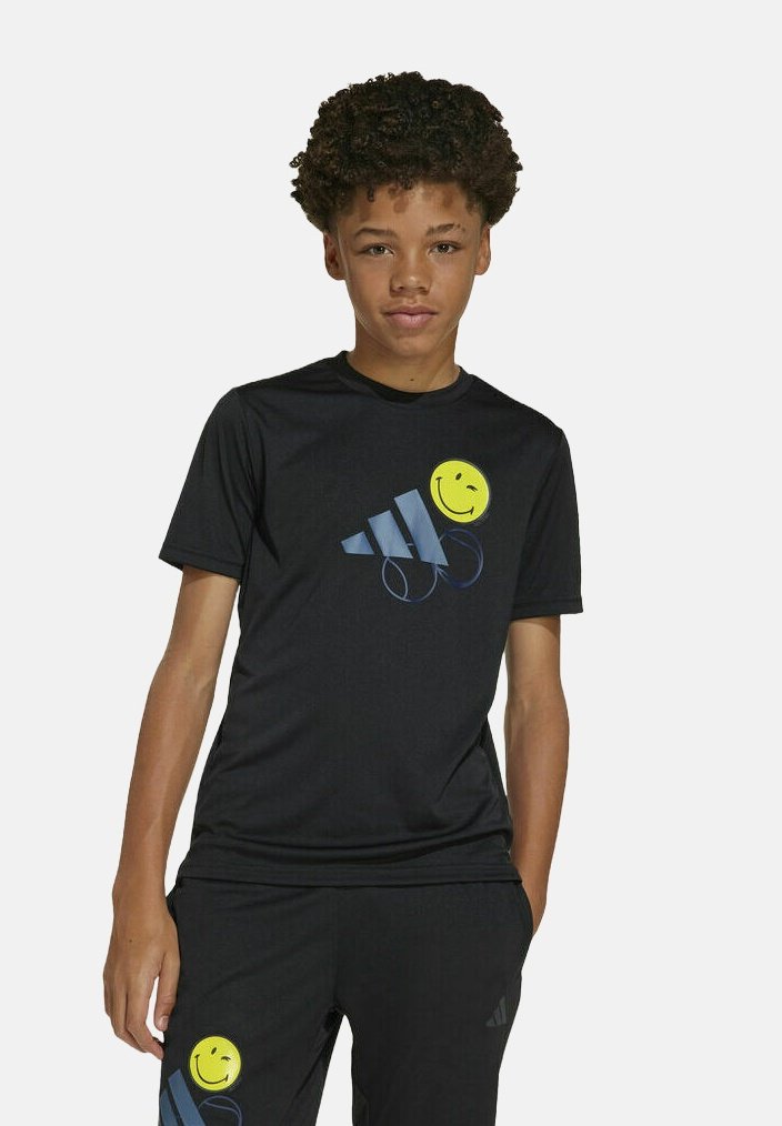 Camiseta deportiva negra con una cara sonriente amarilla y rayas diagonales azules. Mangas cortas, material ligero, textura suave.