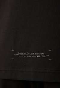 Μαύρο μπλουζάκι με μαλακό ύφασμα, στρογγυλή λαιμόκοψη και λευκή εκτυπωμένη γραφή κοντά στο στρίφωμα που περιγράφει τον σκοπό της σχεδίασής του.