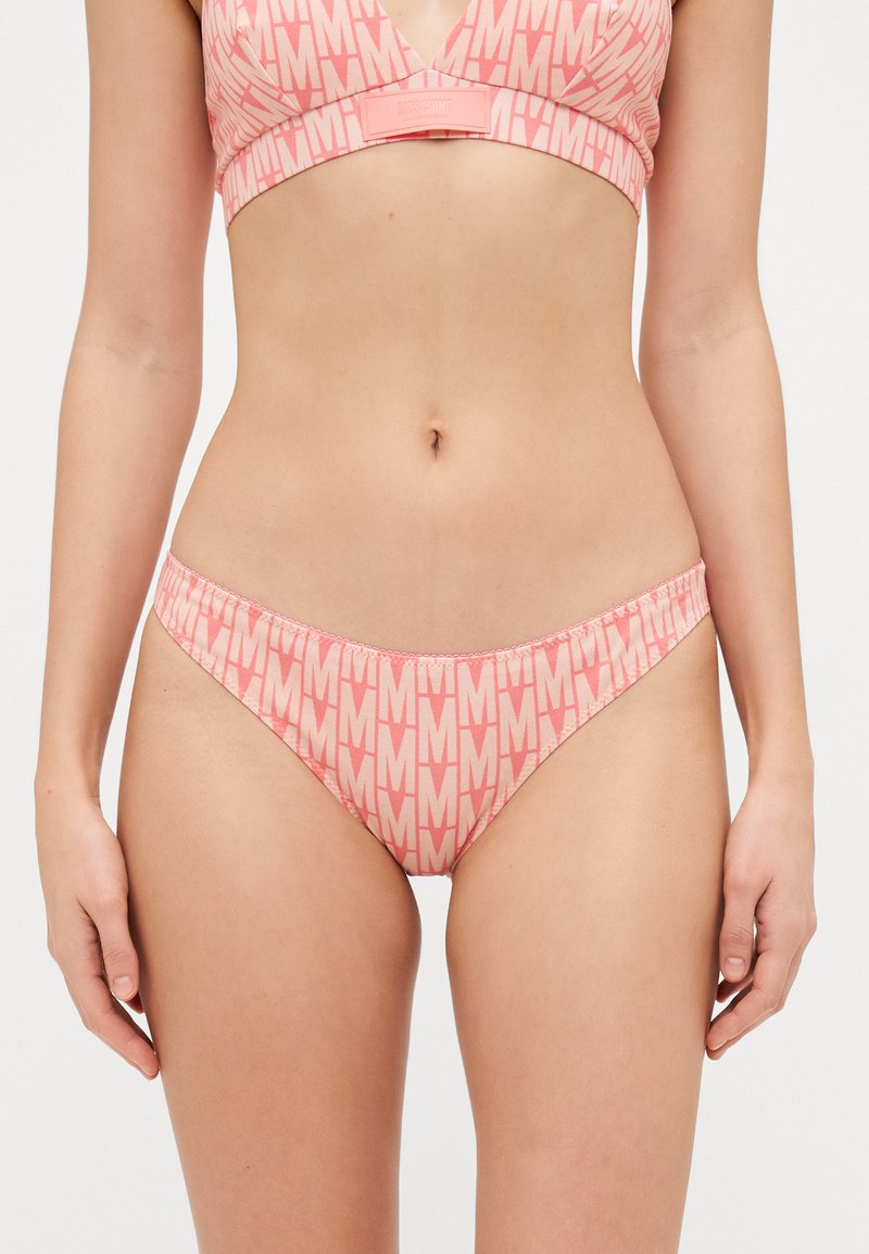 Rózsaszín bikiniszett, amely V-nyakú bralette-ből és hozzá illő tanga bugyiból áll. Az anyag ismétlődő "M" logós mintázattal rendelkezik, puha, sima tapintású.