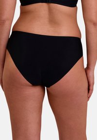 Bas de bikini noir en tissu lisse, présentant un design échancré et une couverture minimale à l'arrière. Les bords sans coutures améliorent le confort.
