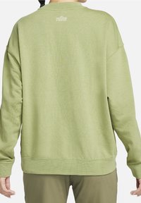 Sweatshirt vert avec une coupe décontractée, col rond et bords côtelés. Présente un subtil logo Nike brodé sur le dos. Texture douce.