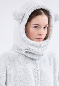 Sudadera de forro polar gris claro con una gran capucha y orejas redondas, textura suave y cuello plegable. Diseño suave y acogedor.