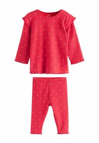 Punainen raidoitettu pitkähihaainen paita, jossa on valkoisia pilkkuja ja volangihihnat, yhdistettynä samasta kuviosta tehtyihin legginsseihin.