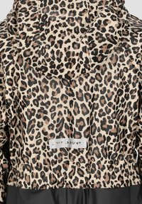 Regnjakke med leopardprint i en beige, sort og brun mønster, med en indsnævret talje og et mærke på ryggen.
