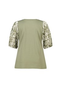 Groene katoenen t-shirt met geborduurde witte bloemenpatronen op de pofmouwen, eenvoudige achterkant en een relaxte pasvorm.