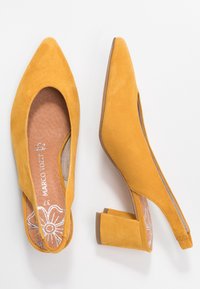 Décolleté gialle in suede con punta affusolata, soletta testurizzata con design floreale e tacco chunky per un migliore supporto.