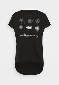 Musta lyhythihainen t-paita, jossa on hopeanvärisiä voikukka-aiheita ja teksti "good things are coming" käsinkirjoitetulla fontilla. Kaarella oleva helma.