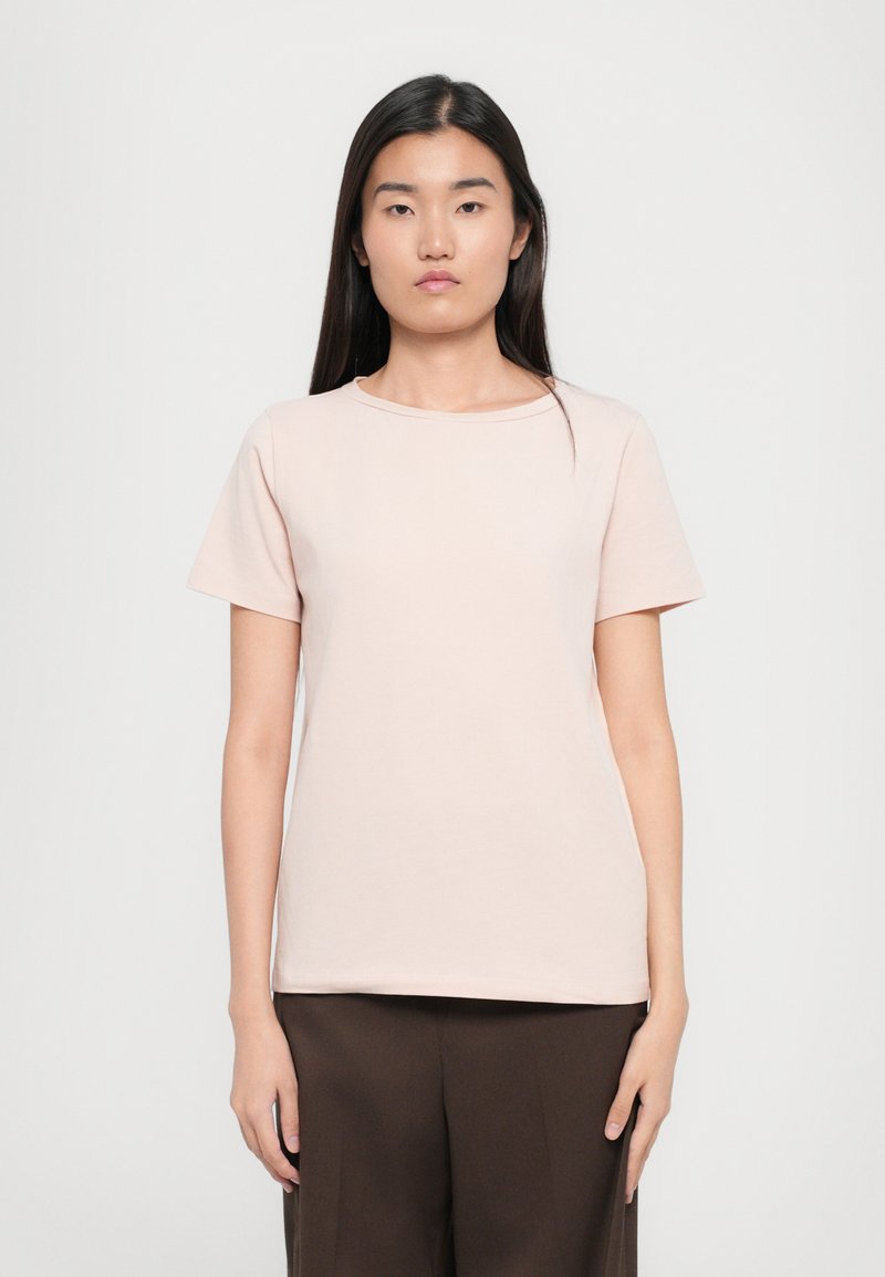 Light pink short-sleeve t-shirt, crew neckline, made of soft fabric, straight cut, paired with brown wide-leg trousers. Simple and minimal design.