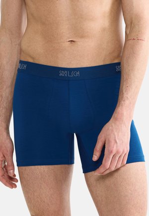 Marineblaue Boxer-Shorts aus weichem Material, mit einem breiten, elastischen Bund, der ein dezentes Logo trägt, enganliegendem Schnitt und glatter Textur.