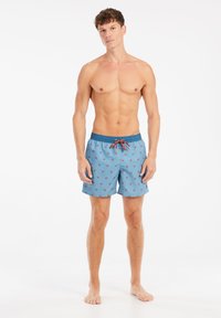 Šviesiai mėlynos spalvos plaukimo šortai su palmės medžių raštu. Savybės: elastingas liemuo, kontrastingas raištelis ir šoninės kišenės.