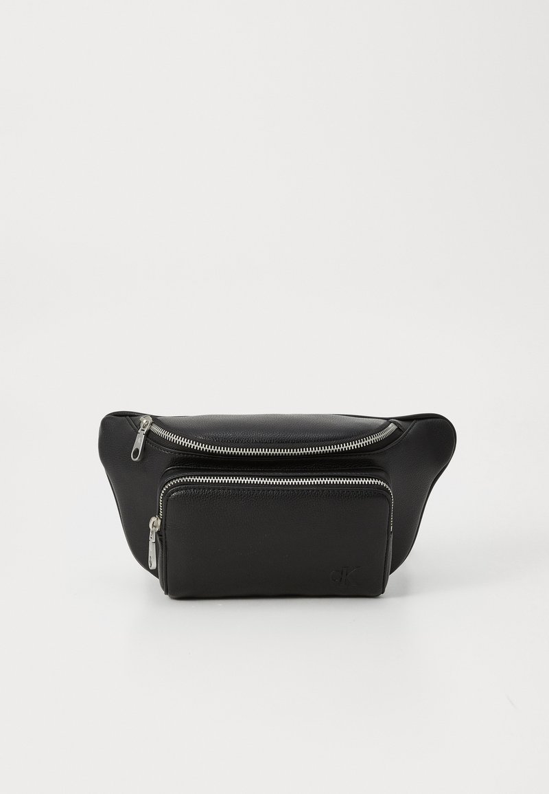 Bolsa de cintura preta em pele com dois compartimentos com fecho, textura suave, forma arredondada e logótipo estampado na frente. Acessórios em metal prateado.