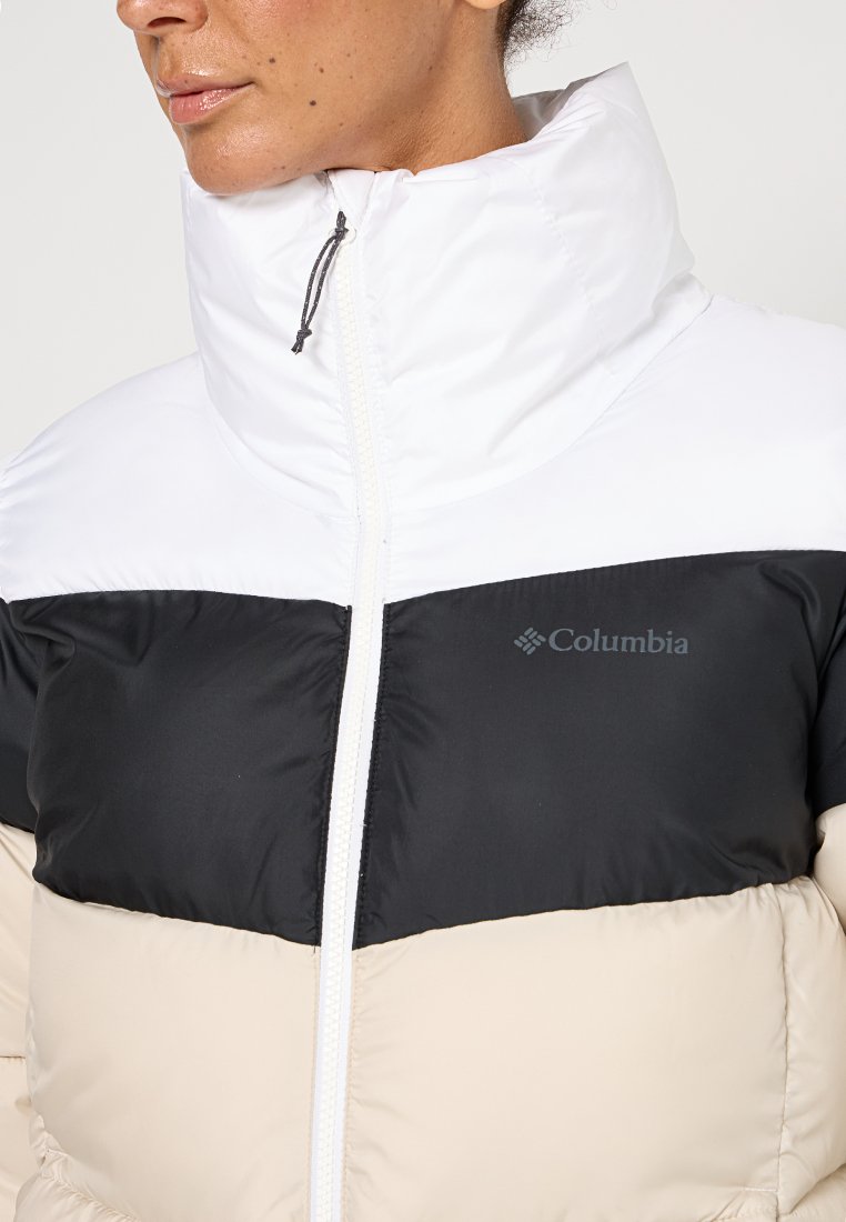 Chaqueta acolchada en blanco, negro y beis con cuello alto; cuenta con cremallera frontal, logo de Columbia en el pecho y textura acolchada.