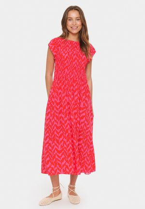 Maxikleid in leuchtendem Pink mit einem kontrastierenden abstrakten Muster. Mit kurzen, gerafften Ärmeln, smockiertem Oberteil und fließendem Rock.