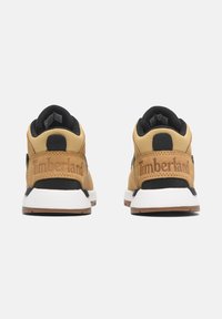 Bruna läder- och textilsneakers med svarta accenter, vita sulor och prägling av logotypdetalj på hälen. Rundad form och vadderad krage.