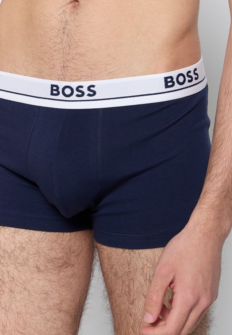 Boxers en coton bleu marine avec une taille élastique blanche présentant le logo "BOSS" en bleu foncé. Texture douce, design ajusté.