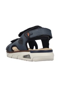 Navy blue sandal with leather and textile upper, adjustable straps, cushioned footbed, and a white rubber sole with air cushioning detail.