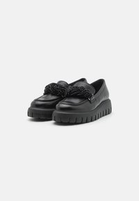 Zwarte lederen schoenen met een dikke, gegroefde zool en een geknoopte parelaccent over de bovenkant. Glad oppervlak met minimale ontwerpelementen.