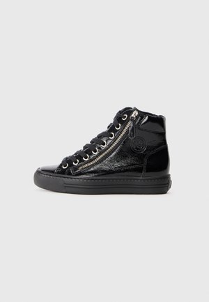 Sort patentlæder højtop sneaker med tyk sål, sidelommer med lynlås og sorte snørebånd på en ensfarvet lys grå baggrund.