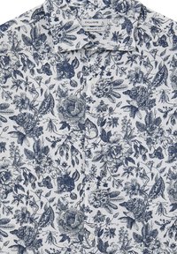 Camicia button-up a fiori navy con sfondo bianco. Vestibilità regolare, design con colletto, presenta illustrazioni botaniche dettagliate e bottoni.
