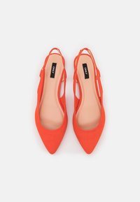 Pair of bright orange pointed-toe slingback flats with beige insoles and black brand labels inside, on a white background.