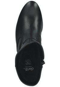 Bottines à talons hauts noires en cuir lisse, dotées d'un bout arrondi et d'une fermeture éclair sur le côté intérieur pour un enfilage facile. Doublure intérieure douce.