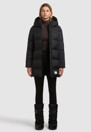 Black puffer coat with a hood, featuring a front zipper and quilted design. Paired with black leggings and insulated knee-high boots.