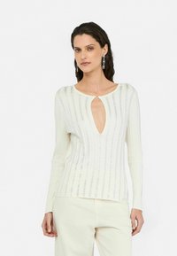 Top a maniche lunghe color crema con una profonda scollatura a chiave, righe orizzontali e una sottile lavorazione a occhiello che attraversa il tessuto.