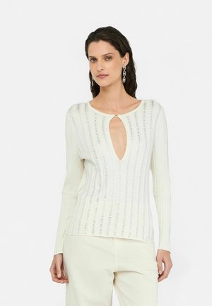 Top a maniche lunghe color crema con una profonda scollatura a chiave, righe orizzontali e una sottile lavorazione a occhiello che attraversa il tessuto.