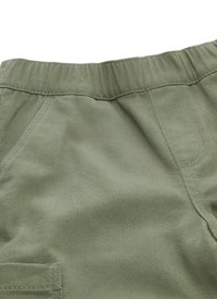 Groene katoenen broek van een gestructureerde ribstof. Bevat een elastische tailleband en zijzakken voor extra functionaliteit.