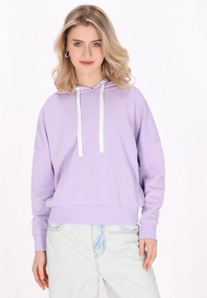 Lilla hoodie med snorhætte, hvid snor, ribbede manchetter og kant; parret med lyse denim jeans. Blød stofstruktur.