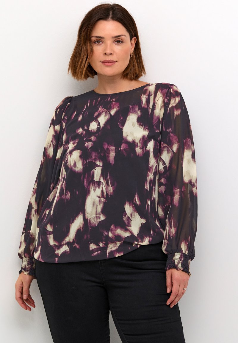 Long-sleeve, purple and cream-patterned blouse with a relaxed fit, sheer fabric, and gathered cuffs. Features a round neckline.