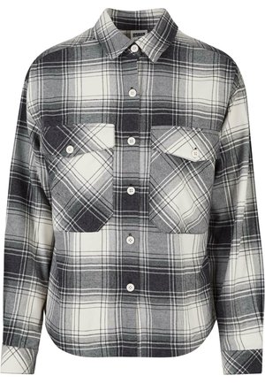 Plaid flannel shirt in black, white, and gray. Features a button-front, two chest pockets, and long sleeves with buttoned cuffs.